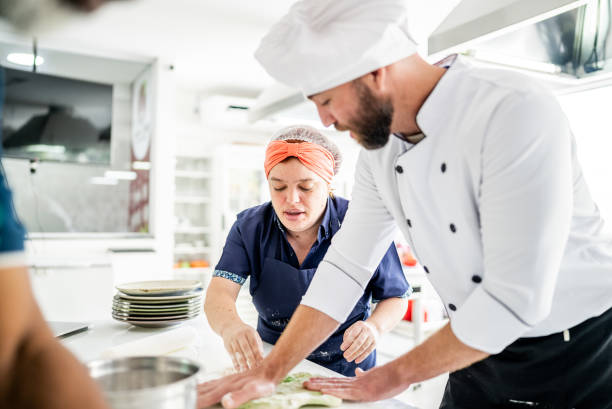 istock Teacher helping a student in a cooking class 1426350321