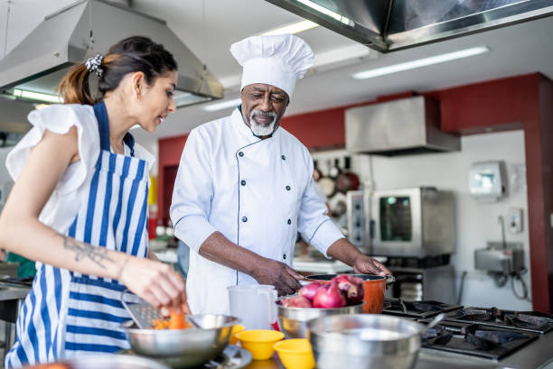 istock Teacher helping a sudent during a cooking class 1426350381