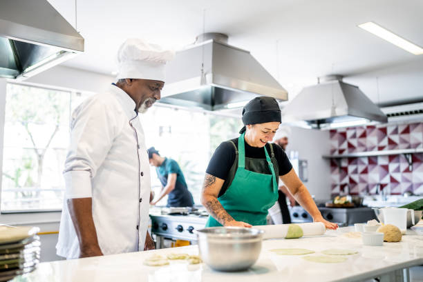 istock Senior chef helping a student making pasta in a cooking class 1426350493