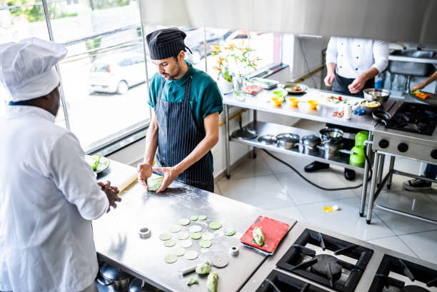 istock Teacher helping a student making pasta in a cooking class 1426350952