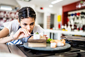 Young woman preparing sushis at the kitchen