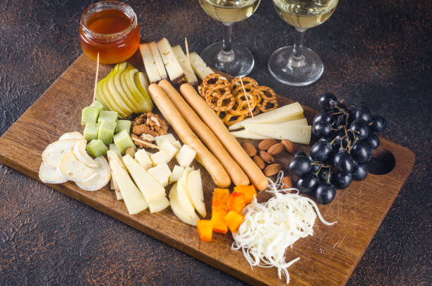 istock Cheese plates served with grapes, jam, snacks, crackers and nuts on a wooden board. 1426352387