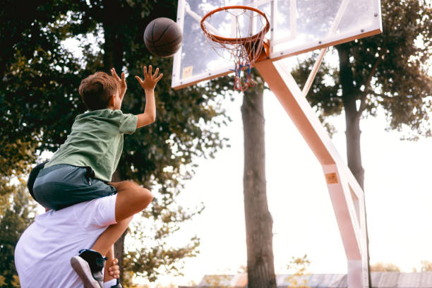 istock Father helps his son to score a basket 1426353939