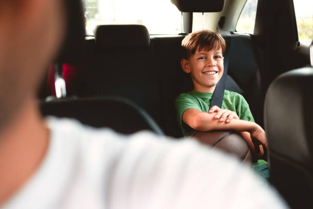 Young Caucasian boy riding in the car, going on a basketball training stock photo
