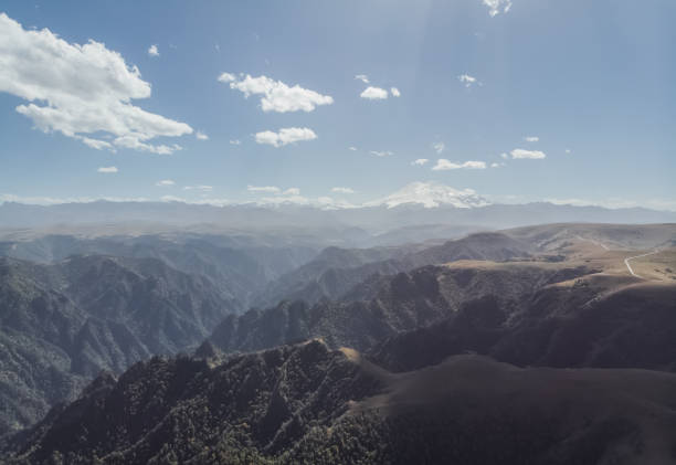 panoramiczny widok na kaukaz i elbrus, mgliste wzgórza z zielonymi lasami, słoneczny wrześniowy dzień z chmurami - sunny day mountain mountain range winter zdjęcia i obrazy z banku zdjęć