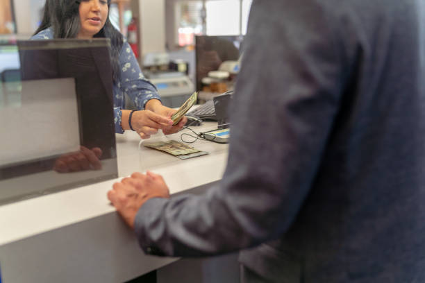 cajero bancario contando dinero para el cliente - mostrador en el banco fotografías e imágenes de stock