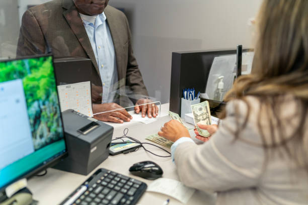 Bank teller counting money for customer