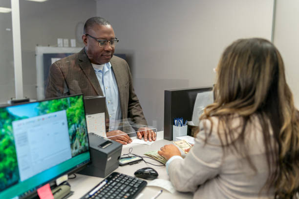 istock Bank teller counting money for customer 1426365116
