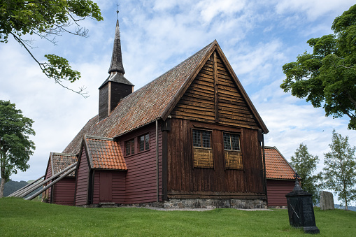 Kvernes, Norway - July 03, 2022: Kvernes Stave Church is a former parish church of the Church of Norway in Averoy Municipality in More og Romsdal county. Cloudy summer day. Selective focus