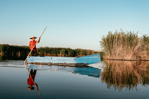 Chinese traditional fishing boat on a lake, HuanHuanXi park, Chengdu, China