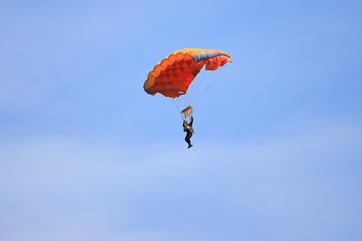 Kyiv, Ukraine - 24 august, 2021: Male skydiver descends on a parachute against the blue sky