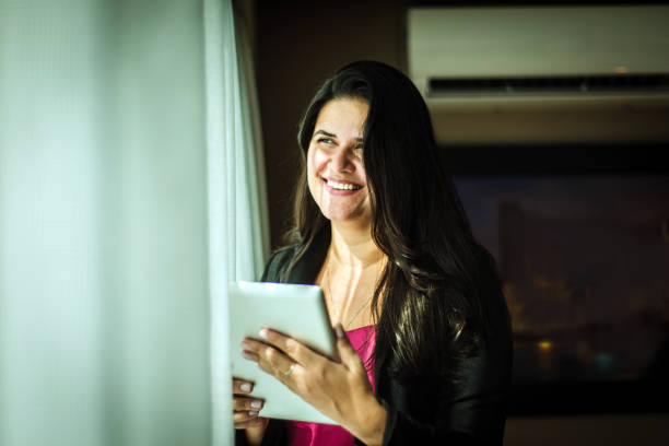 istock Woman with tablet. Looking out the window. 1426379408
