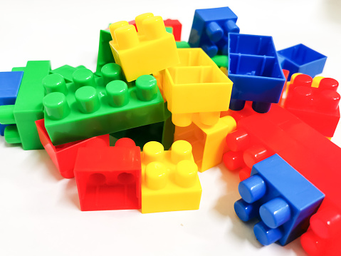 Colorful plastic building blocks against white background. Education and development concept.