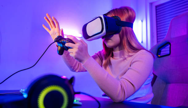 istock Gamer in VR headset glasses exploring metaverse plays online video game touching something on air and hold joystick 1426410945