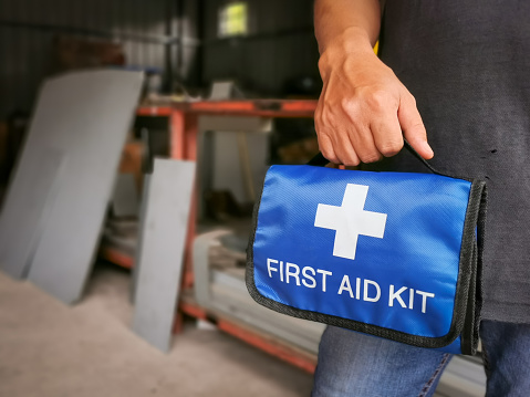 Worker holding first aid kit bag in the factory.