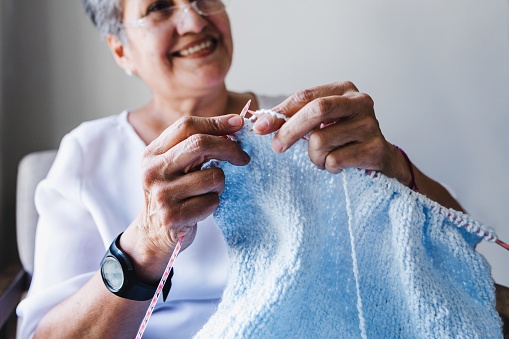 hispanic Grandmother knitting at home in Mexico Latin America