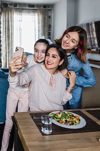 hispanic women Family Mother and daughters Posing For photo Selfie at dinner time At Home in Latin America