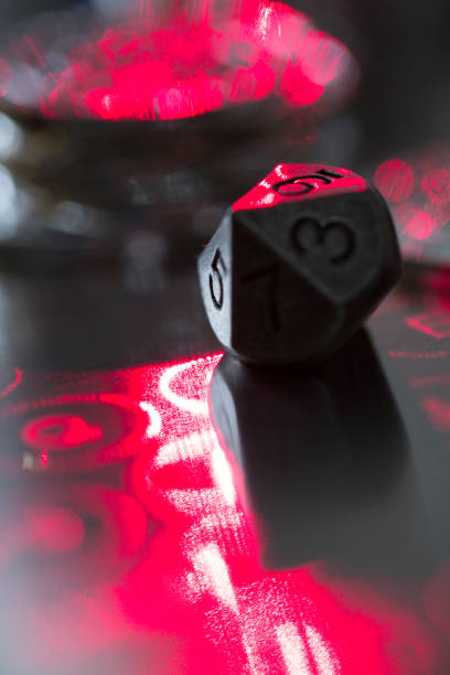 istock Artificial micro-model, metal positive polyhedral number dice shining under red laser 1426439125
