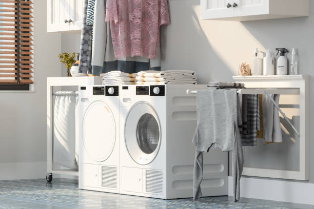 lavanderia com máquina de lavar roupa, secador e roupas penduradas no rack de secagem - laundromat clothes washer laundry utility room - fotografias e filmes do acervo