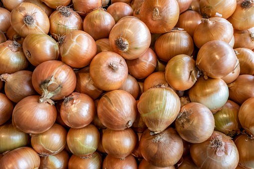 Brown onions piled on a stall.
