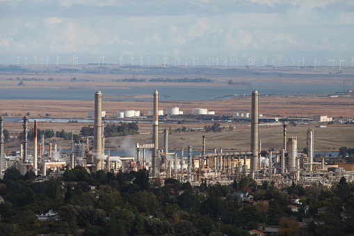 Martinez, California / USA - December 7 2019: An image of the Former Shell Refinery in Martinez, California. Now it's owned by PBF Energy. This image was taking from the Martinez hills. In the background wind turbines can be seen.
