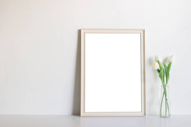 istock A white wooden frame and green leaves with natural light. 1426449123