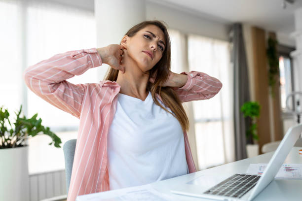 istock Feeling exhausted. Frustrated woman looking exhausted and massaging her neck while sitting at her working place 1426455161