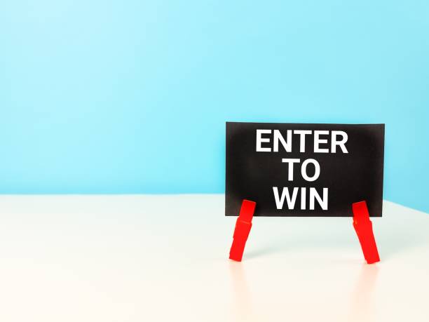istock Black paper card written enter to win on the table. 1426456077