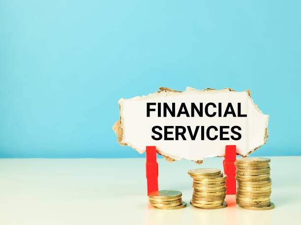 istock Cupboard strip written financial services with coins stack on the table. 1426457208