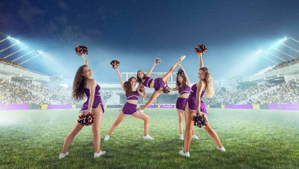 istock Group of cheerleaders in action on  stadium in night 1426457502