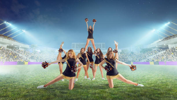 istock Group of cheerleaders in action on  stadium in night 1426457797