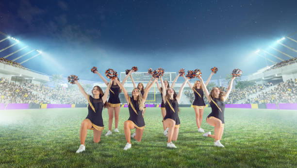 istock Group of cheerleaders in action on  stadium in night 1426457858
