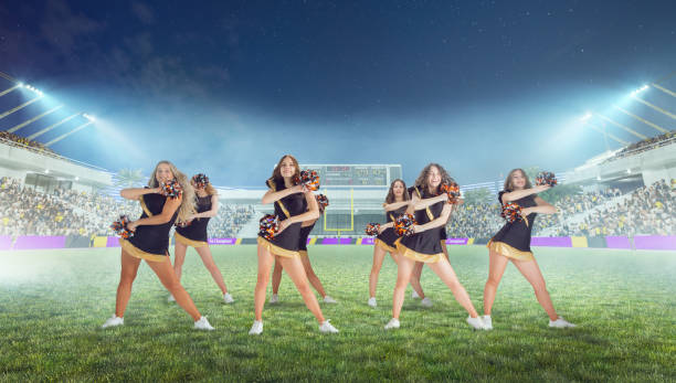 istock Group of cheerleaders in action on  stadium in night 1426457979