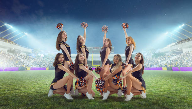 istock Group of cheerleaders in action on  stadium in night 1426458556