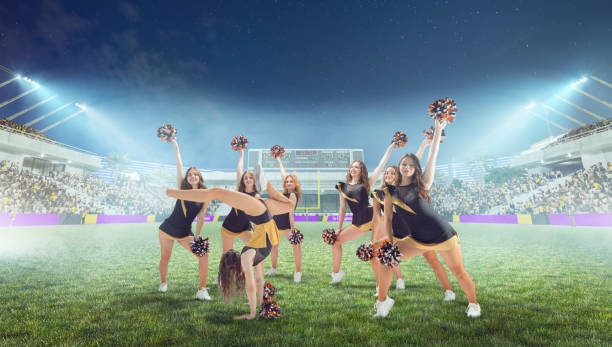 istock Group of cheerleaders in action on  stadium in night 1426458558