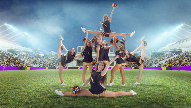 istock Group of cheerleaders in action on  stadium in night 1426458587