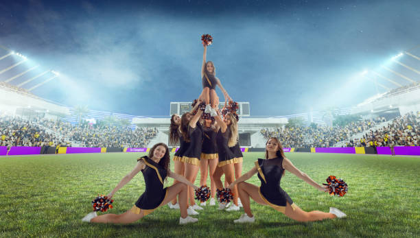 Group of cheerleaders in action on  stadium in night
