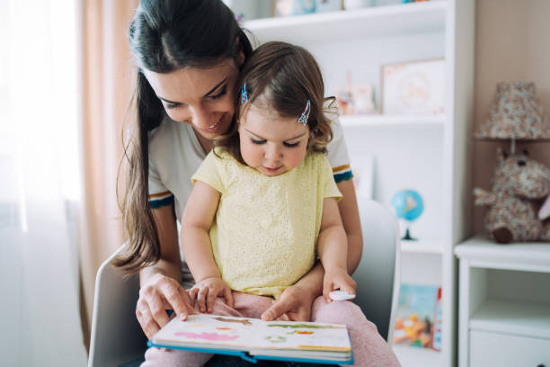 istock Mother and her little daughter reading a book. 1426459356