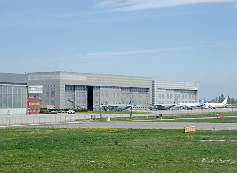 Venice, Italy - April 19, 2022: Hangars at Marco Polo Airport in Venice with military aircraft and planes belonging to the Sukhoi Superjet 100 initiative of Superjet International, a joint enterprise between Italian and Russian businesses.