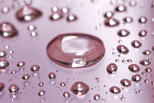 istock A large drop and splashes of micellar water on a pink background. 1426468562