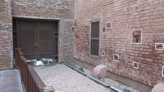 White empty brick cracked wall background on sidewalk of city