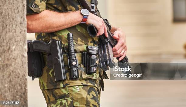 Detail Of A Guard In Camouflage Uniform With Machine Gun In Hand And Pistol Baton Stun Grenade And Radio On His Belt Stock Photo - Download Image Now