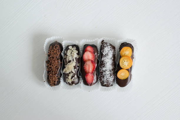 Delicious pastries with chocolate icing and berries on the table.