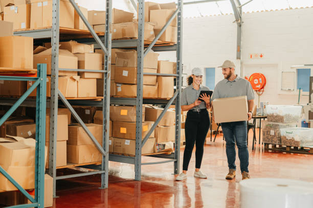 istock Warehouse manager, digital tablet logistics and shipping box delivery workers in wholesale factory, distribution depot and industry. Staff planning online stock, courier package and export production 1426479174