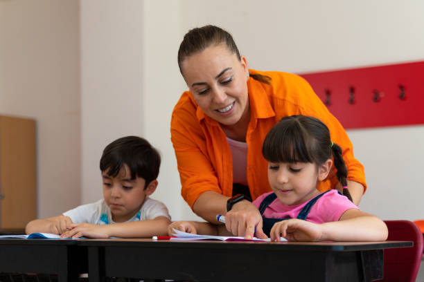 grupa ludzi, chłopców i dziewcząt z nauczycielem w prywatnej szkole podstawowej na klasie. - dzień nauczyciela zdjęcia i obrazy z banku zdjęć