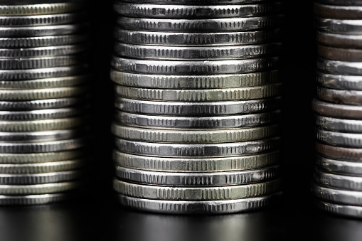 Stacks of metallic coins on a dark background