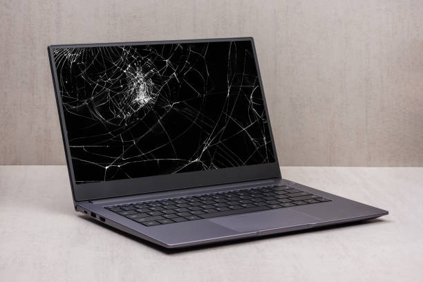 laptop with a broken screen in cracks on a gray background close up with clipping path