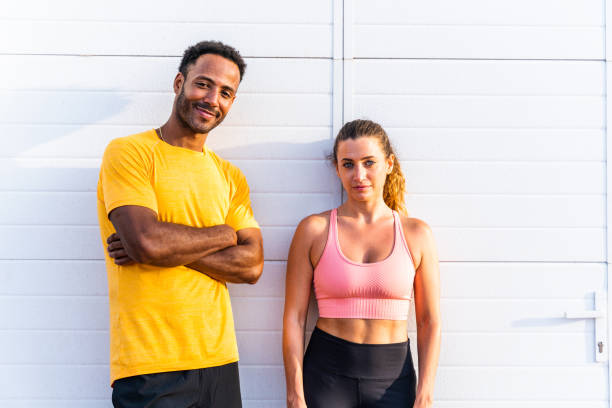 Interracial sportive couple training outdoors - Multiracial couple wearing sportswear and doing functional workout outdoors to strenght body muscles, core abs, stamina and cardio