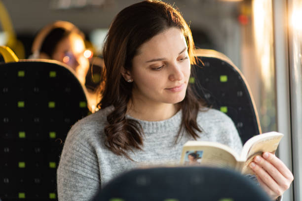 istock Woman reading a book in bus 1426501108