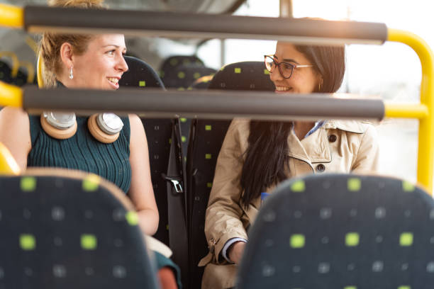 istock Two female friends sitting and talking in bus 1426501837